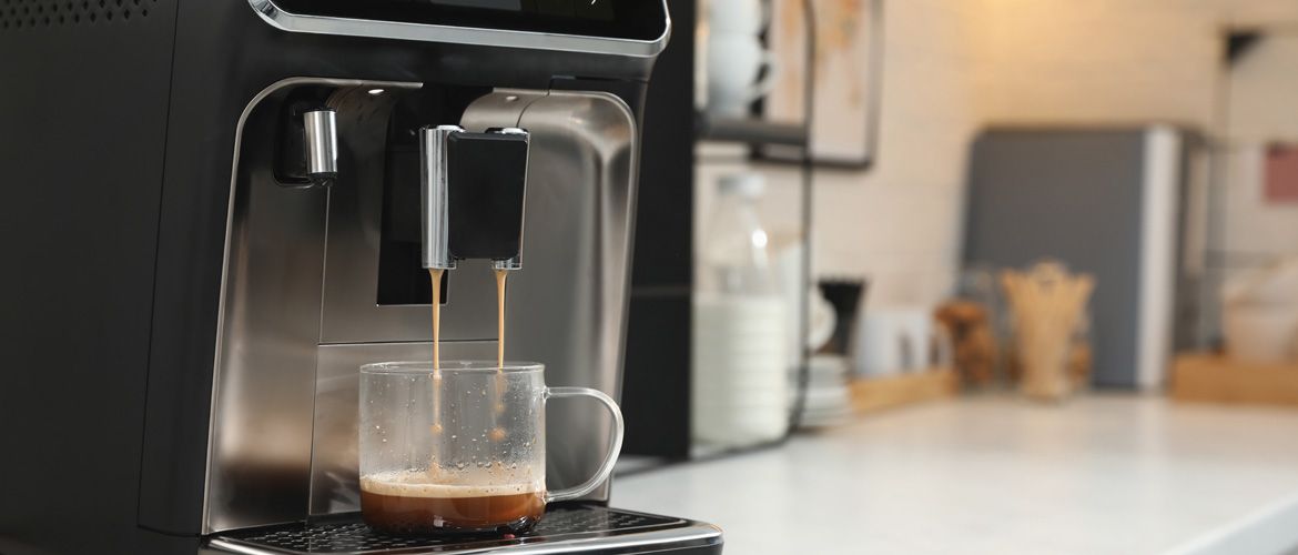 Modern coffee machine making espresso in kitchen